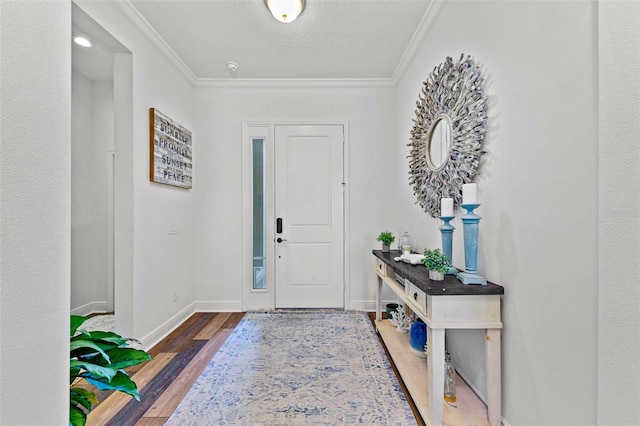 entrance foyer with a textured ceiling, ornamental molding, and dark hardwood / wood-style flooring