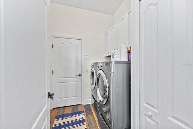 washroom featuring cabinets, dark wood-type flooring, and washer and dryer