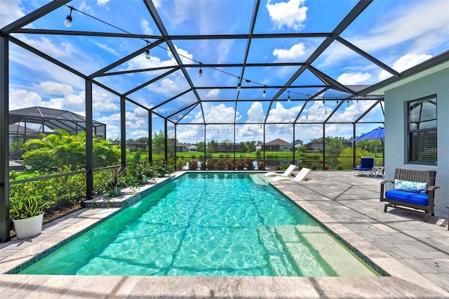 view of swimming pool featuring a lanai and a patio area