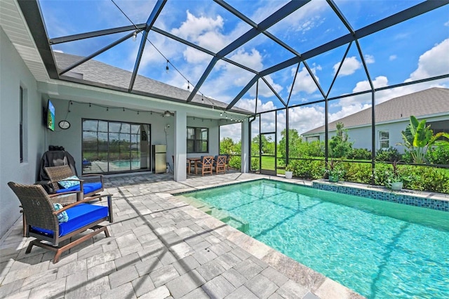 view of pool with a patio and glass enclosure