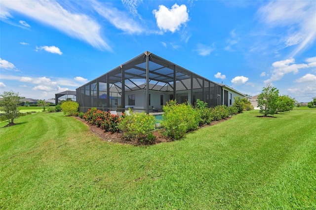 rear view of property with glass enclosure and a yard