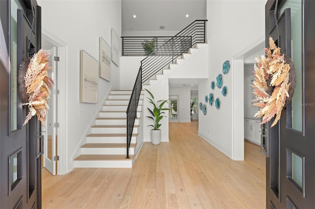 foyer featuring light hardwood / wood-style flooring and a towering ceiling