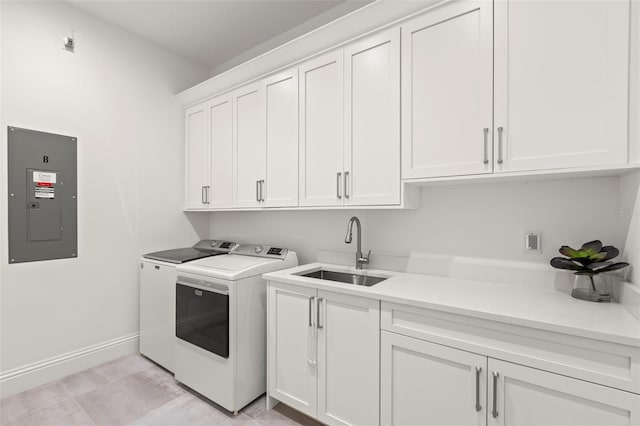 clothes washing area with cabinets, electric panel, sink, and washing machine and clothes dryer