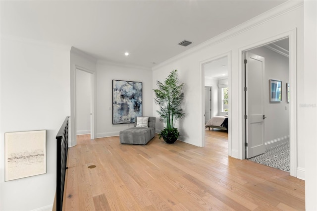 sitting room with light hardwood / wood-style flooring and ornamental molding