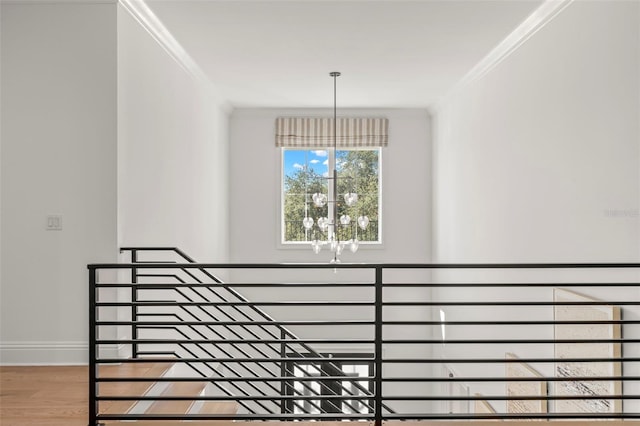 staircase featuring a chandelier, hardwood / wood-style flooring, and crown molding