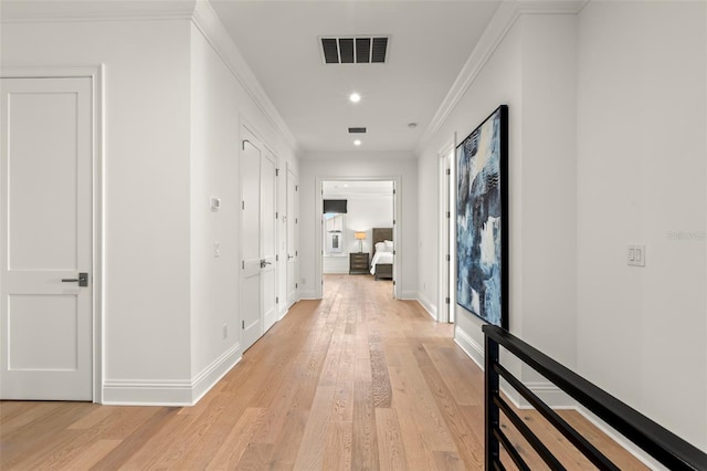 hallway featuring ornamental molding and light wood-type flooring