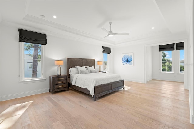 bedroom with ornamental molding, light hardwood / wood-style floors, a raised ceiling, and ceiling fan