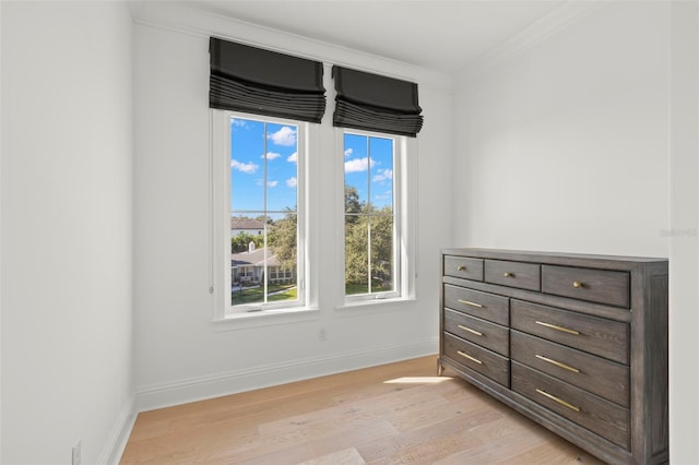 bedroom featuring multiple windows, ornamental molding, and light hardwood / wood-style flooring