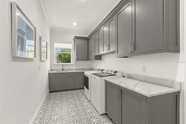 washroom featuring cabinets, sink, crown molding, and washing machine and dryer