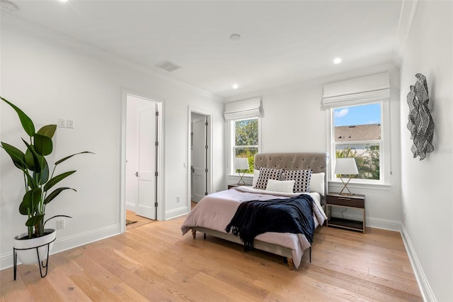 bedroom with light wood-type flooring and ornamental molding