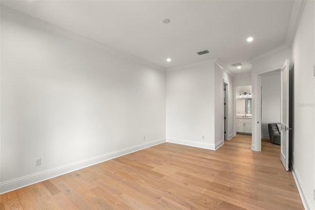 unfurnished bedroom with ornamental molding, ensuite bath, and light hardwood / wood-style floors