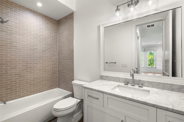 full bathroom featuring tiled shower / bath combo, vanity, and toilet