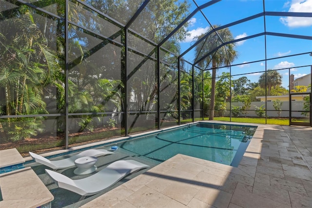 view of pool with glass enclosure and a patio area