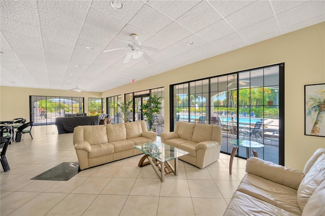 living room with ceiling fan, light tile patterned floors, and a healthy amount of sunlight