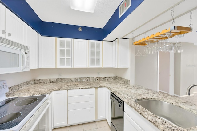 kitchen with dishwasher, stove, white cabinets, sink, and light tile patterned flooring