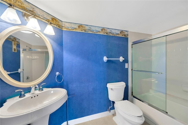 full bathroom with shower / bath combination with glass door, tile patterned floors, toilet, and sink