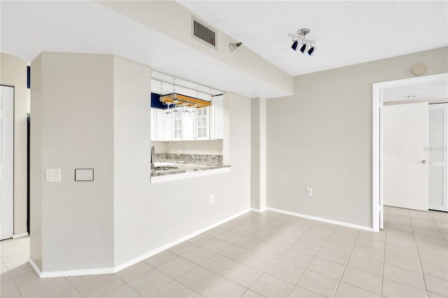 empty room featuring sink and light tile patterned floors