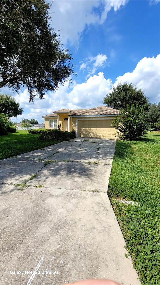 view of front of home with a front lawn and a garage