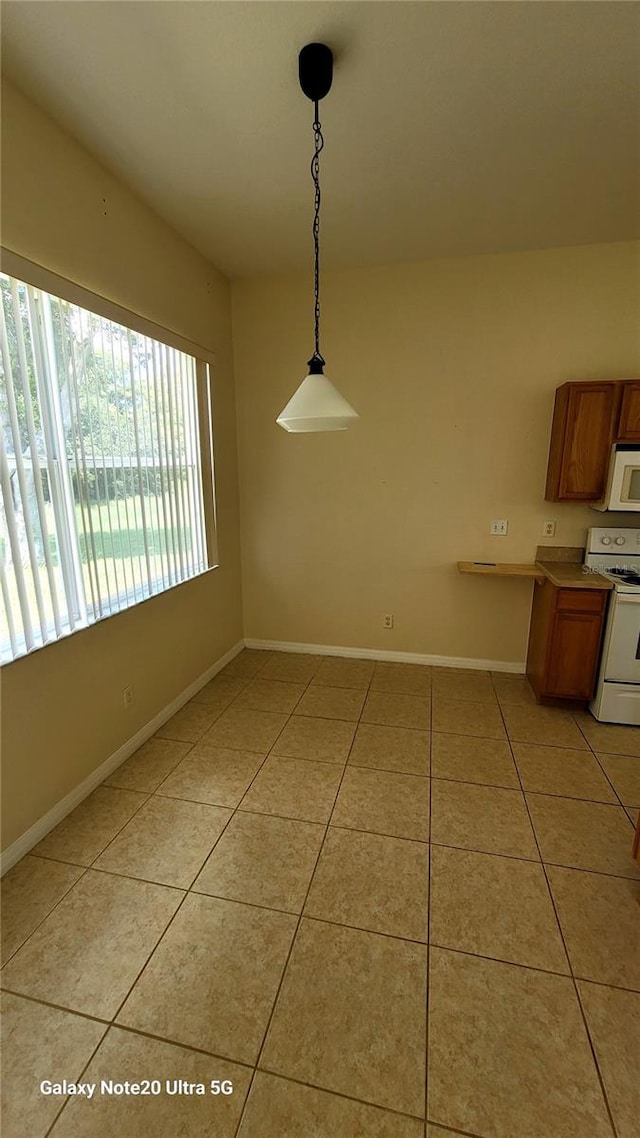 unfurnished dining area with light tile patterned flooring