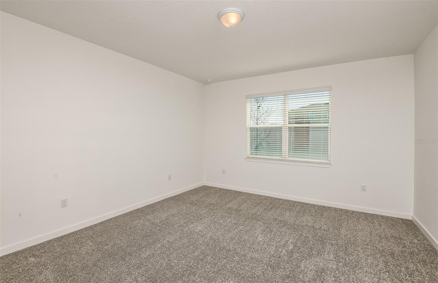 carpeted spare room with baseboards