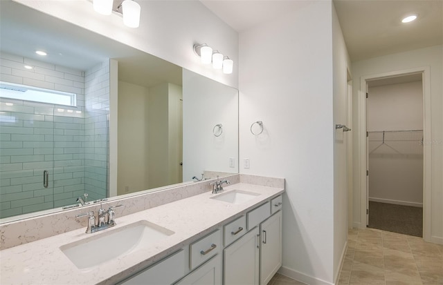 full bath featuring baseboards, a sink, a walk in closet, and a shower stall