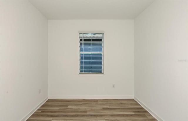 unfurnished room with wood finished floors and baseboards