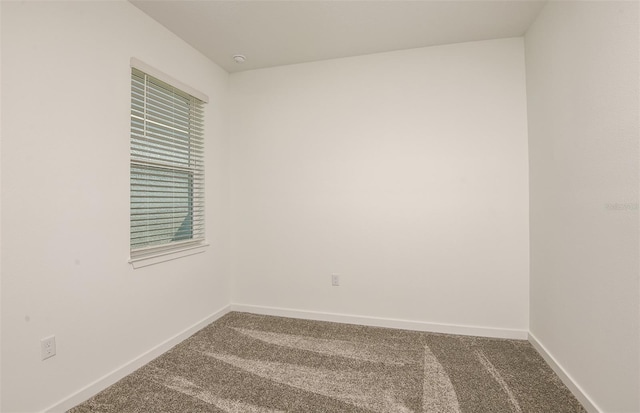 carpeted empty room with baseboards