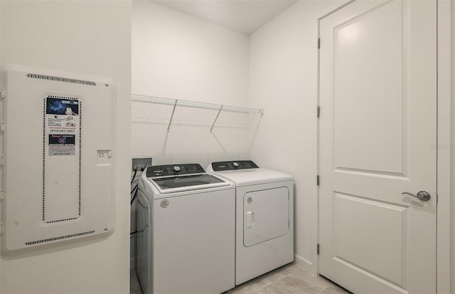 clothes washing area with light tile patterned floors, laundry area, and washer and dryer