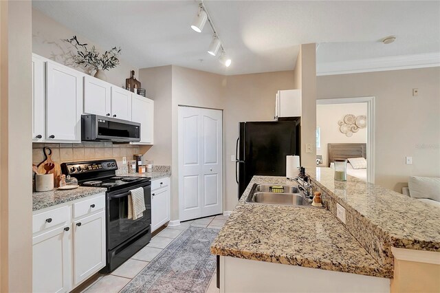 kitchen with sink, white cabinets, rail lighting, black appliances, and light stone countertops