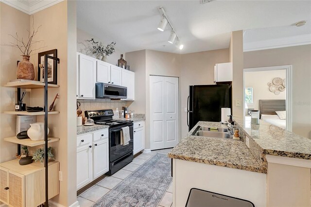 kitchen featuring light stone countertops, black appliances, white cabinetry, and sink