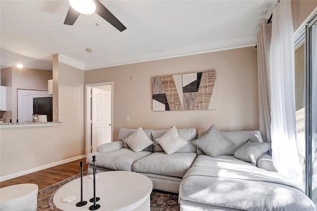 living room with ornamental molding, wood-type flooring, and ceiling fan