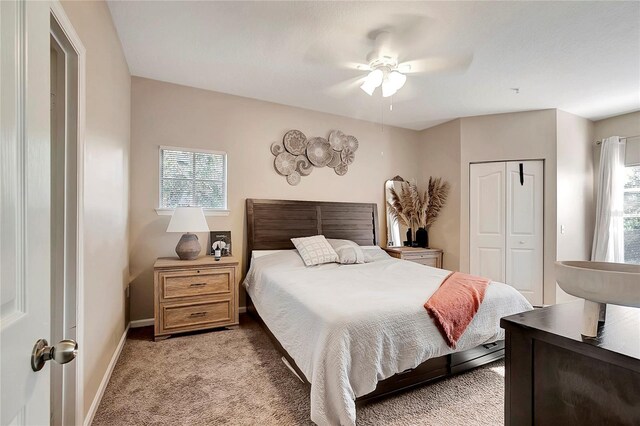 bedroom with ceiling fan, light colored carpet, a closet, and multiple windows