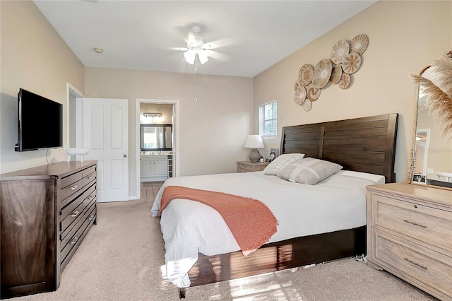 carpeted bedroom with ensuite bath and ceiling fan