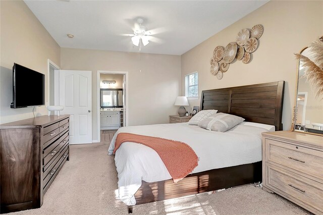bedroom with connected bathroom, a ceiling fan, and light colored carpet