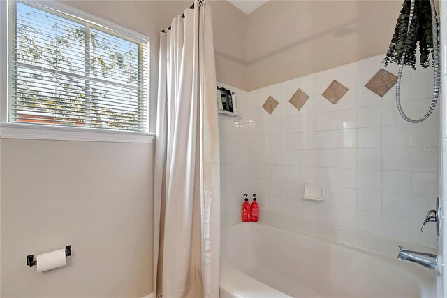 bathroom with shower / bath combo with shower curtain