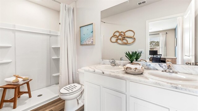 bathroom with hardwood / wood-style flooring, vanity, toilet, and walk in shower