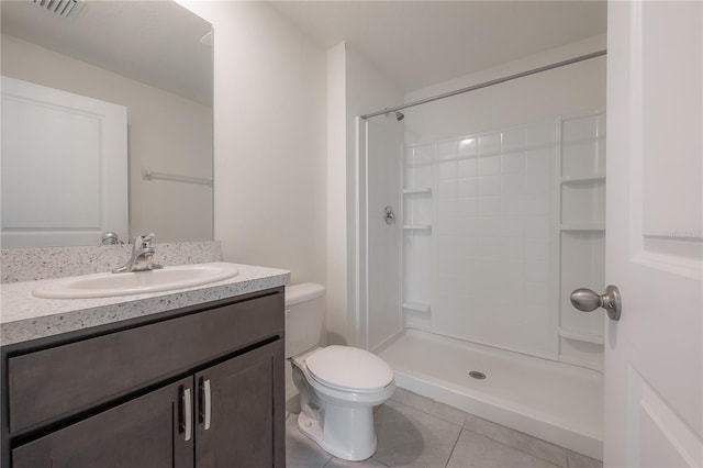 bathroom featuring walk in shower, vanity, toilet, and tile patterned floors