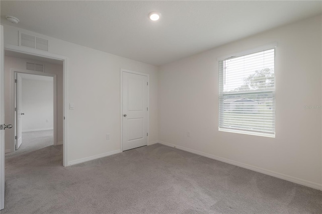 unfurnished bedroom featuring light carpet and a closet