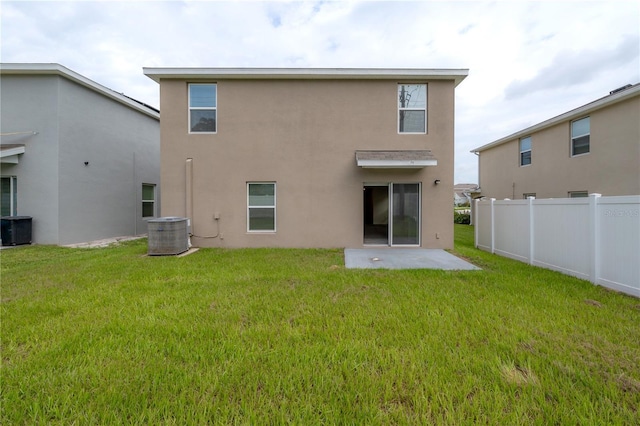 rear view of house featuring a lawn and central air condition unit