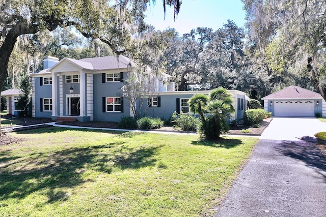 view of front facade with a garage, an outdoor structure, and a front lawn