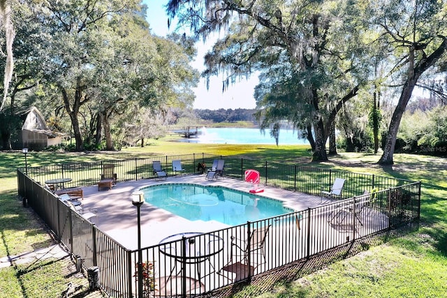 view of swimming pool with a lawn, a water view, and a patio area