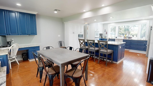 dining room with wood-type flooring and built in desk