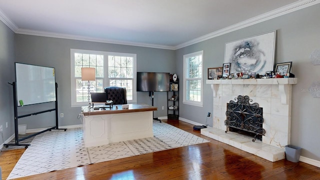 office space with light wood-type flooring, crown molding, and a fireplace