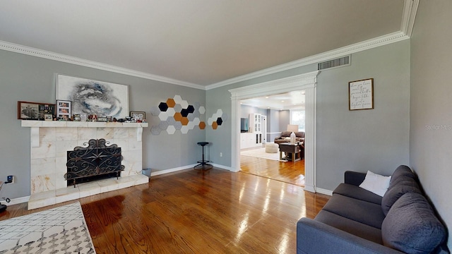 living room featuring crown molding, hardwood / wood-style floors, and a high end fireplace