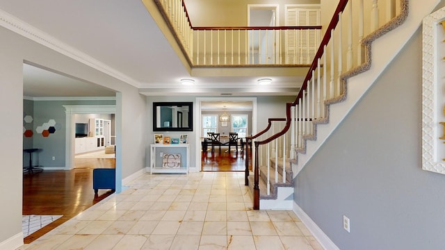 entrance foyer with ornamental molding and hardwood / wood-style floors