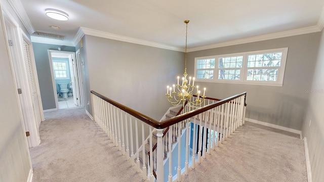 stairway featuring crown molding, a chandelier, and carpet