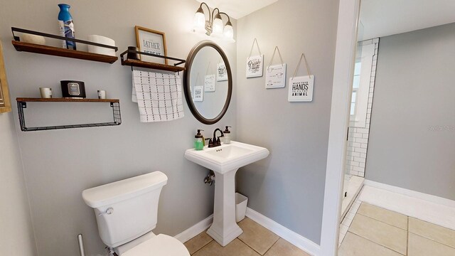 bathroom featuring a shower, toilet, and tile patterned floors