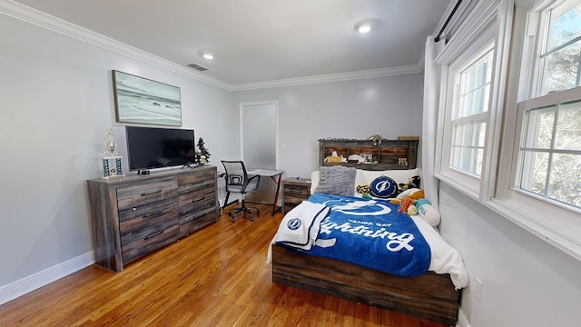 bedroom with crown molding and hardwood / wood-style floors