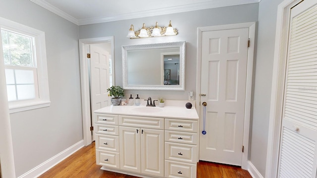 bathroom with ornamental molding, vanity, and hardwood / wood-style flooring