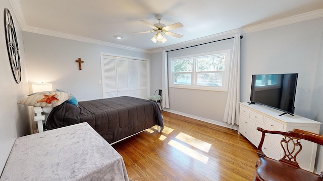 bedroom featuring a closet, wood-type flooring, ceiling fan, and ornamental molding